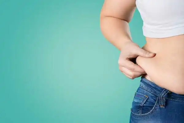Image of woman pinching her love handles to show weight gain Barr Common